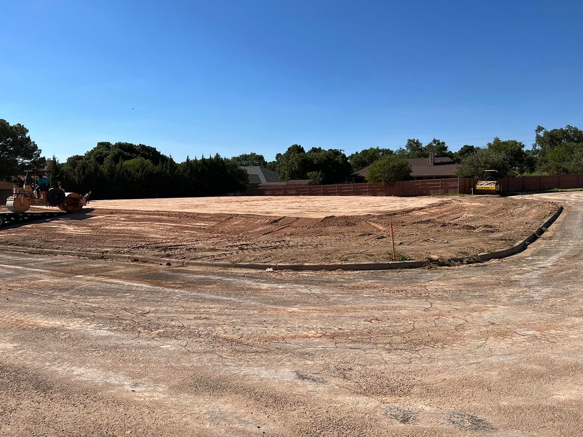 Leveled construction site with heavy machinery preparing land.